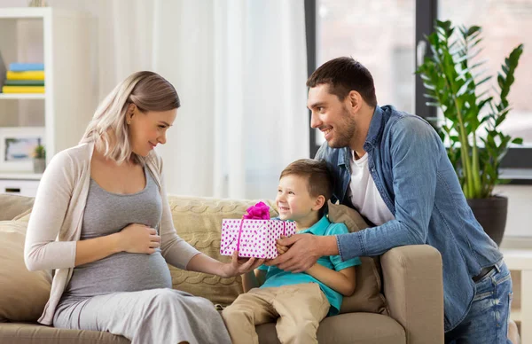 Famille donnant cadeau à la mère enceinte à la maison — Photo