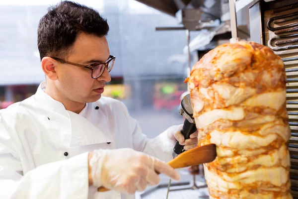 Chef rebanando carne doner de escupir en la tienda de kebab —  Fotos de Stock