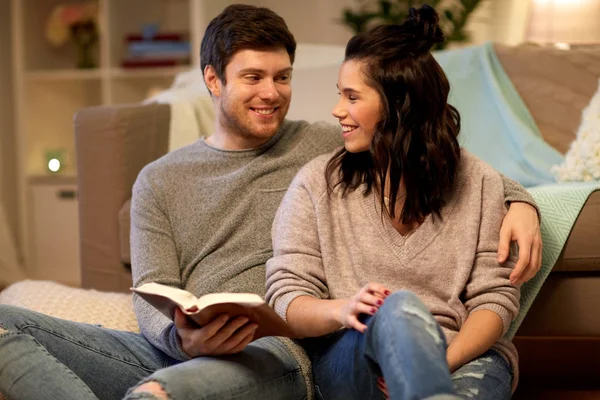Happy couple reading book at home — Stock Photo, Image