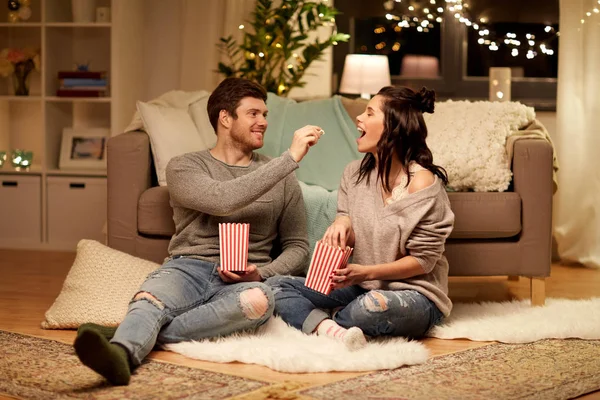 Coppia felice mangiare popcorn a casa — Foto Stock