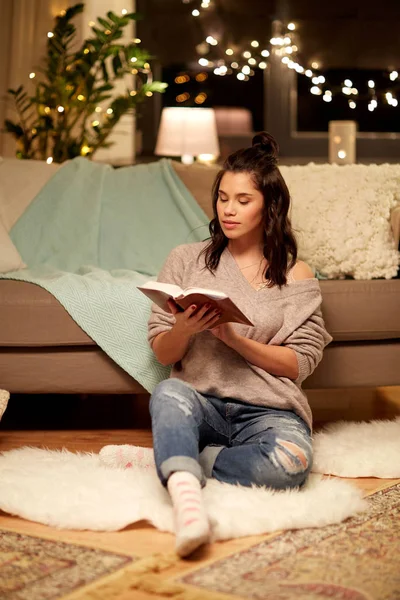 Heureuse jeune femme lecture livre à la maison — Photo