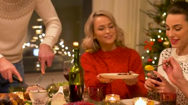 Amigos felices teniendo la cena de Navidad en casa — Vídeo de stock