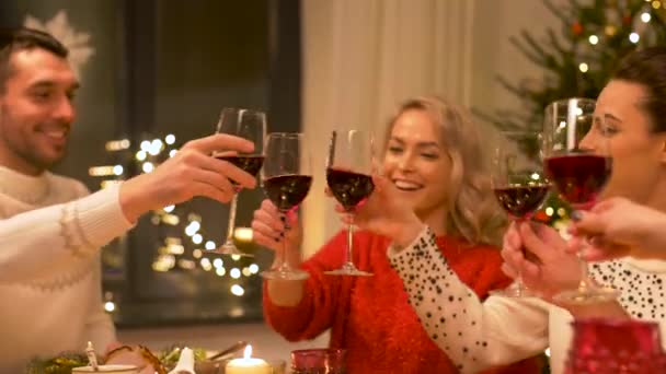 Счастливые друзья пьют красное вино на Рождество — стоковое видео