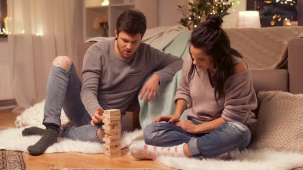 Happy couple playing block-stacking game at home — Stock Video