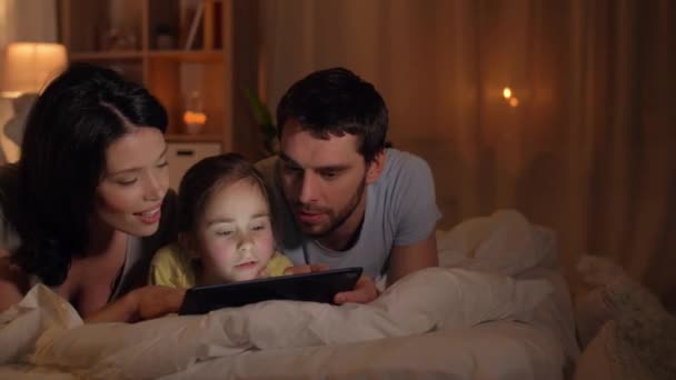 Happy family with tablet pc in bed at home — Stock Video