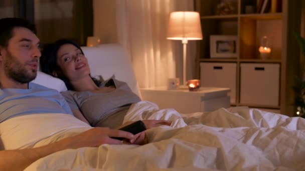 Casal feliz assistindo tv na cama em casa — Vídeo de Stock