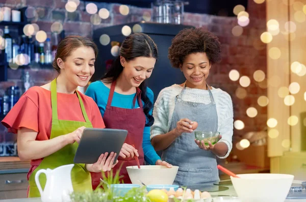 Femmes heureuses avec tablette pc cuisine dans la cuisine — Photo