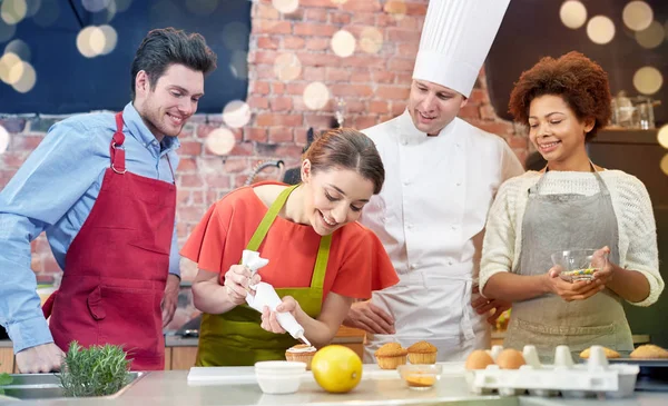 Amigos felizes e cozinheiro chef assar na cozinha — Fotografia de Stock