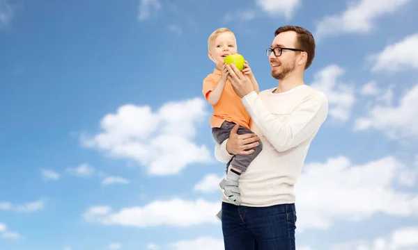 Pai feliz e filho pequeno com maçã verde — Fotografia de Stock