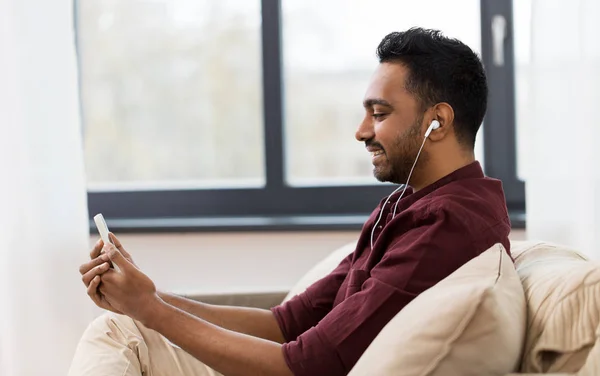 Homem em fones de ouvido ouvir música no smartphone — Fotografia de Stock