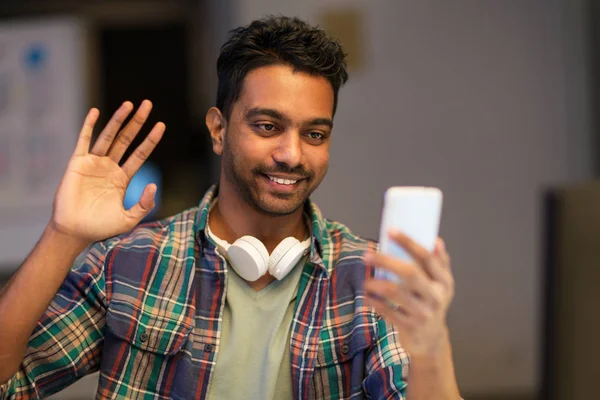 Hombre con smartphone que tiene videollamada en la oficina —  Fotos de Stock