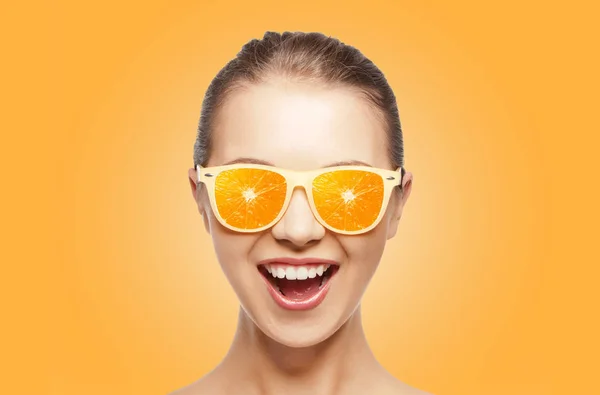 Fröhliches Teenager-Mädchen mit Sonnenbrille und Orangen — Stockfoto