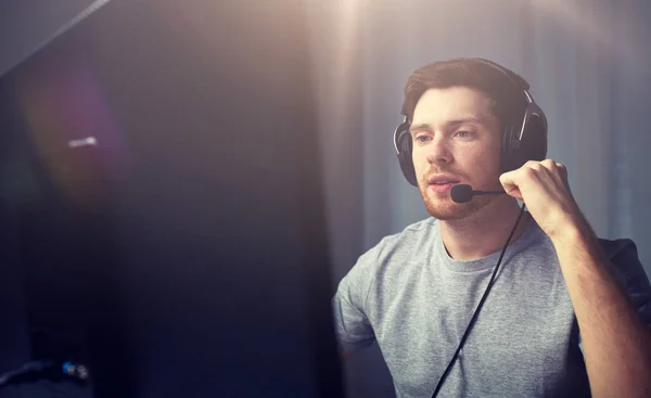 Hombre en auriculares jugando videojuego de ordenador en casa —  Fotos de Stock