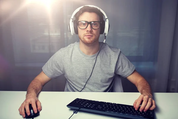 Man in headset playing computer video game at home — Stock Photo, Image