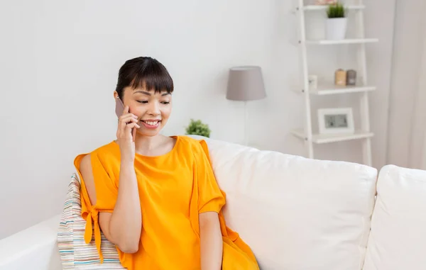 Feliz mulher asiática chamando no smartphone em casa — Fotografia de Stock