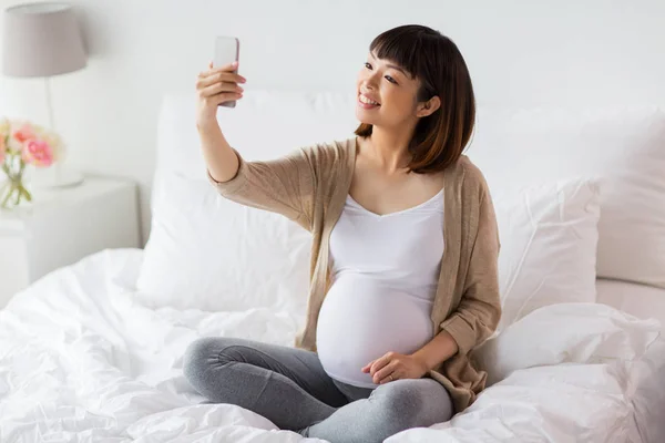 Schwangere macht Selfie mit Smartphone zu Hause — Stockfoto
