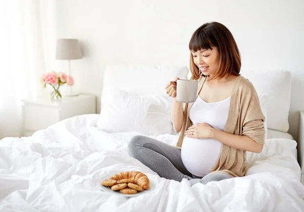 幸福的怀孕女人，坐在家里喝茶的杯 — 图库照片