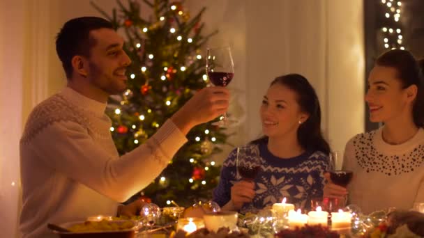 Счастливые друзья пьют красное вино на Рождество — стоковое видео
