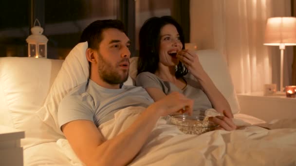 Koppel met popcorn kijken tv 's nachts thuis — Stockvideo