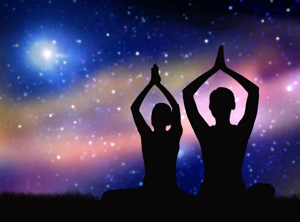 Black silhouette of couple meditating over space — Stock Photo, Image