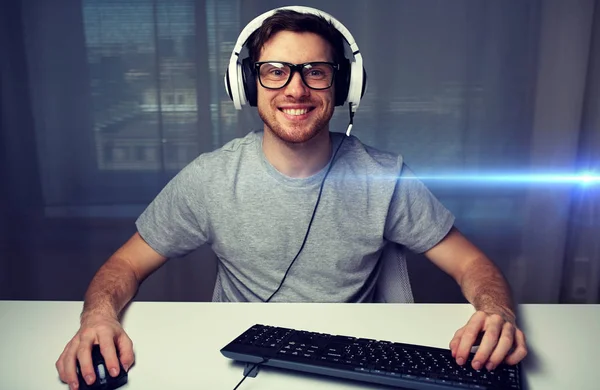 Чоловік в гарнітурі грає в комп'ютерну відеогру вдома — стокове фото