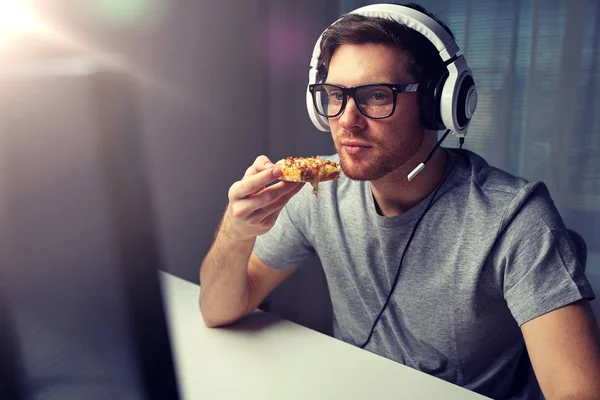 Homem em fone de ouvido jogando jogo de computador em casa — Fotografia de Stock