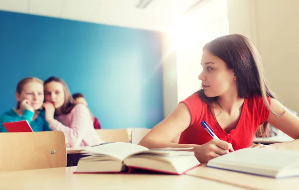 Estudiantes chismorreando detrás de su compañero de clase en la escuela — Foto de Stock