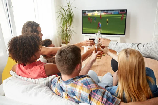 Amigos tintineo cerveza y viendo juego de fútbol —  Fotos de Stock