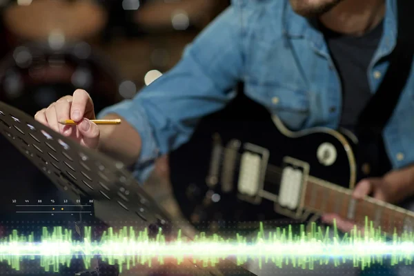 Muzikant met gitaar en muziek boek bij studio — Stockfoto