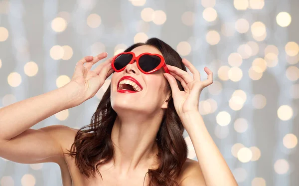 Femme avec rouge à lèvres rouge et nuances en forme de coeur — Photo