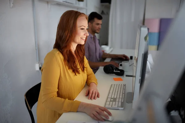 Lykkelig kvinne med datamaskin som arbeider på kontoret – stockfoto