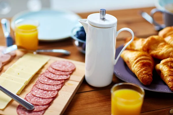 Koffiepot en voedsel op geserveerd tafel bij het ontbijt — Stockfoto