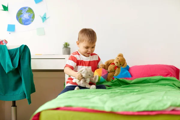 Glücklicher kleiner Junge spielt zu Hause mit Plüschtieren — Stockfoto