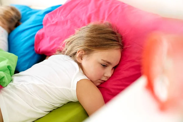 Niña acostada despierta en la cama en casa —  Fotos de Stock