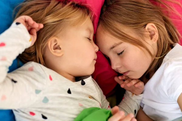 Mutlu küçük kızlar evde yatakta uyuyor — Stok fotoğraf