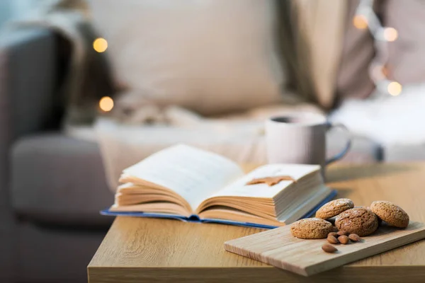 Oat cookies, almonds and book on table at home — Stock Photo, Image