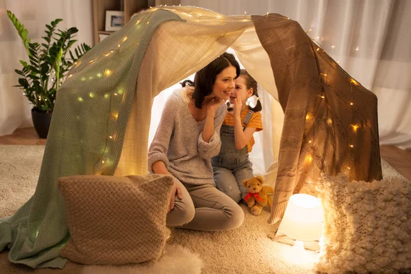 Família feliz sussurrando na tenda crianças em casa — Fotografia de Stock