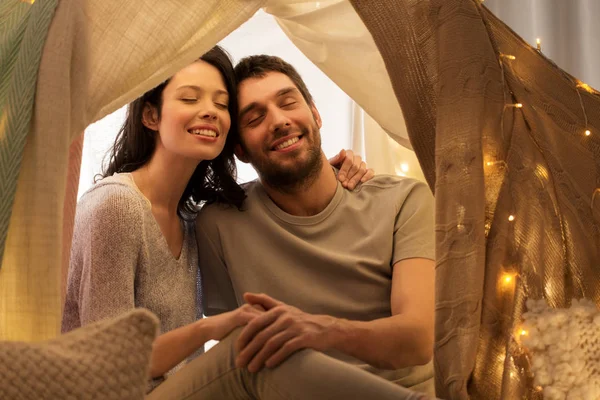 Happy couple in kids tent at home — Stock Photo, Image