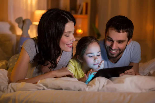 Geceleri evde yatakta tablet pc ile aile — Stok fotoğraf