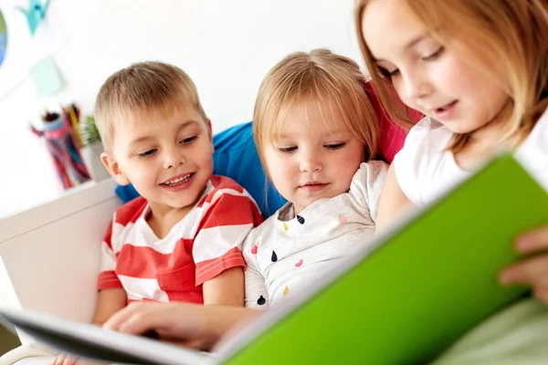 Kleine kinderen lezen boek in bed thuis — Stockfoto