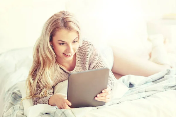 Feliz joven con la tableta de la PC en la cama en casa —  Fotos de Stock