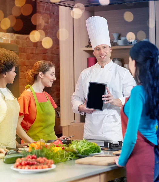 Szczęśliwe kobiety z szefa kuchni i tablet pc w kuchni — Zdjęcie stockowe