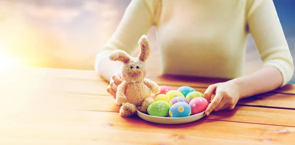 Close up of woman hands with easter eggs and bunny — Stock Photo, Image