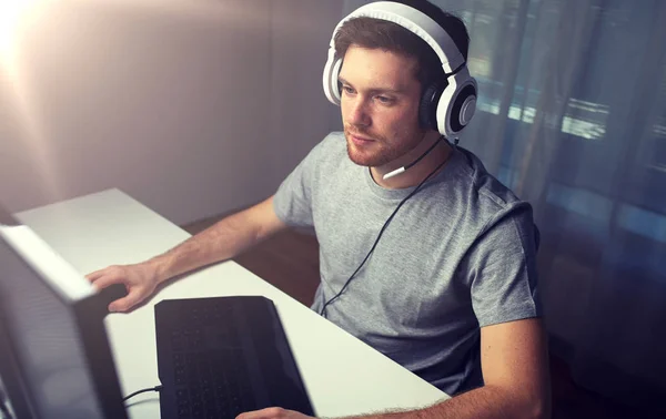Człowiek w słuchawki gry gry wideo komputera w domu — Zdjęcie stockowe