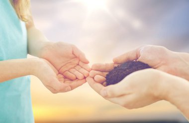 close up of father and daughter hands holding soil clipart