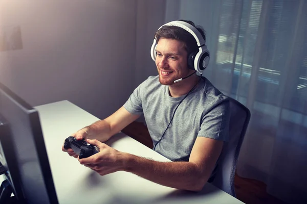 Mann mit Headset spielt Computervideospiel zu Hause — Stockfoto