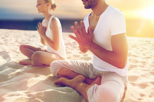 Zblízka pár meditoval na pláži — Stock fotografie