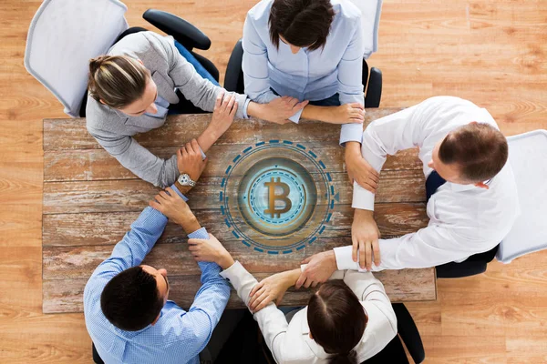 Tim bisnis dengan hologram bitcoin berpegangan tangan — Stok Foto