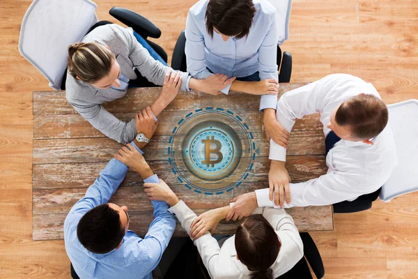 Equipo de negocios con el holograma bitcoin de la mano — Foto de Stock