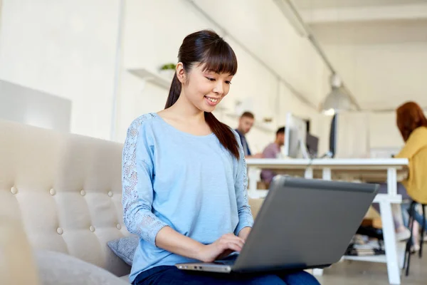 Feliz mujer asiática con portátil de trabajo en la oficina —  Fotos de Stock